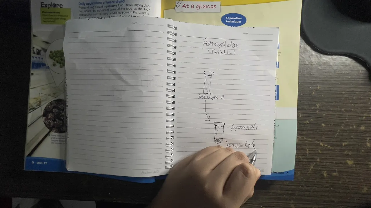 A person writing by hand in an open notebook