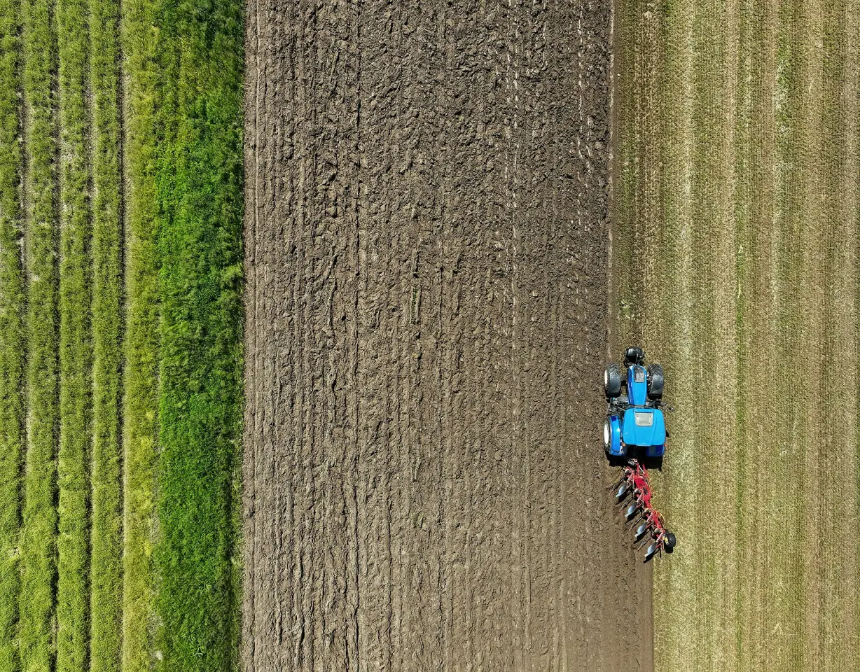 A tractor ploughing a field from above