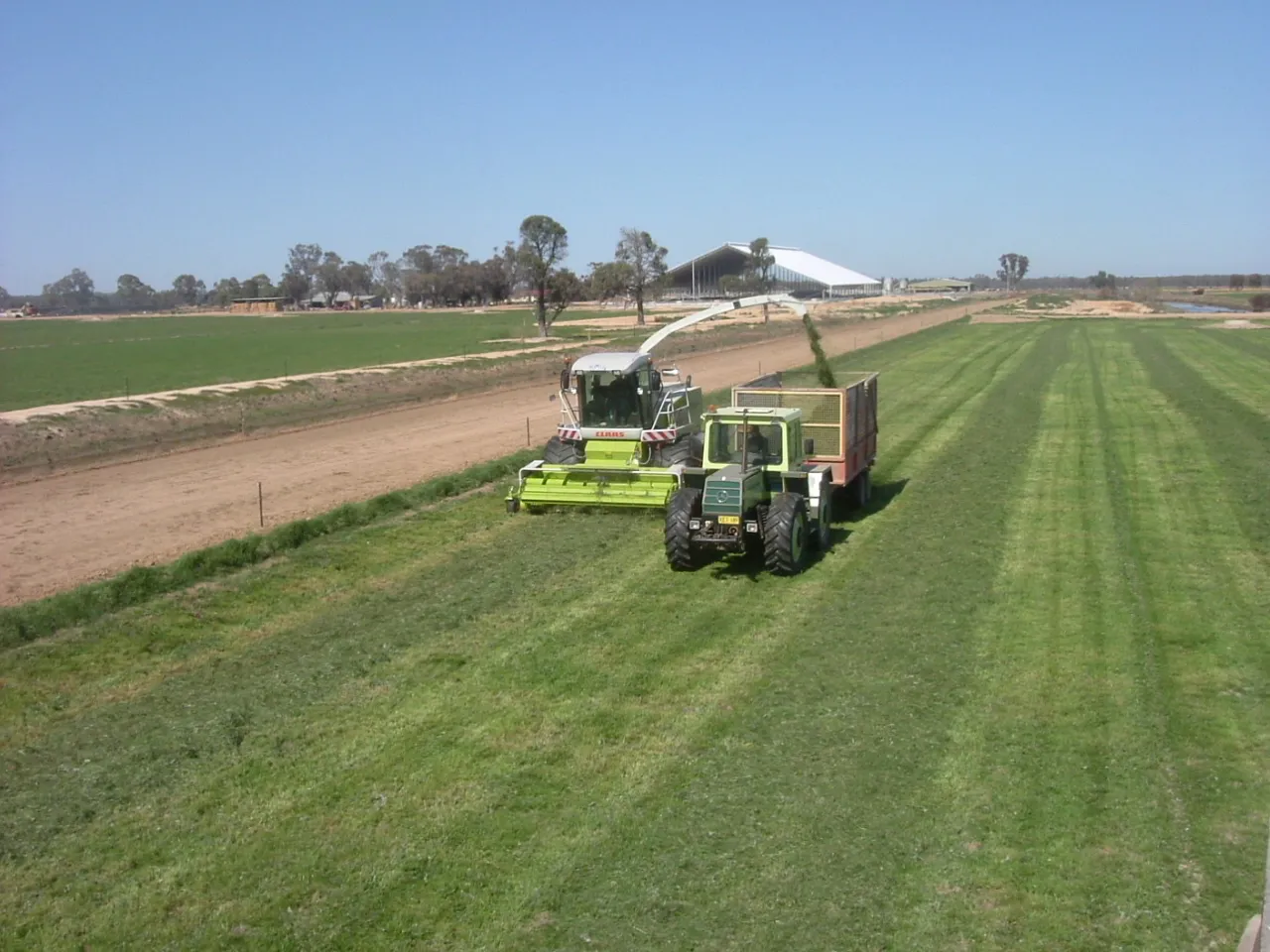 Harvester and tractor working together during farm operations