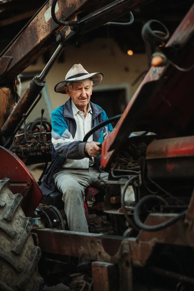 Man repairing a tractor in a rural setting